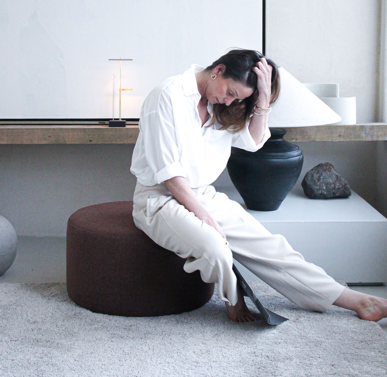 Live Light | Sofie Noyen in her living space on the Barrow pouf with the Knokke table tamp in the back Live Light | Sofie Noyen in her living space on the Barrow pouf with the Knokke table tamp in the back